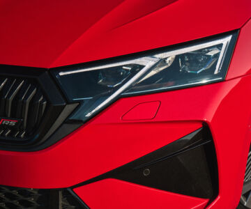 Close-up of the headlight and front grille of the 2025 Skoda Octavia RS in red