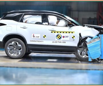 Frontal crash test of Tata Harrier EV with dummies and deployed airbags visible.