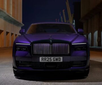 Front view of Rolls-Royce Spectre in purple under urban night lights
