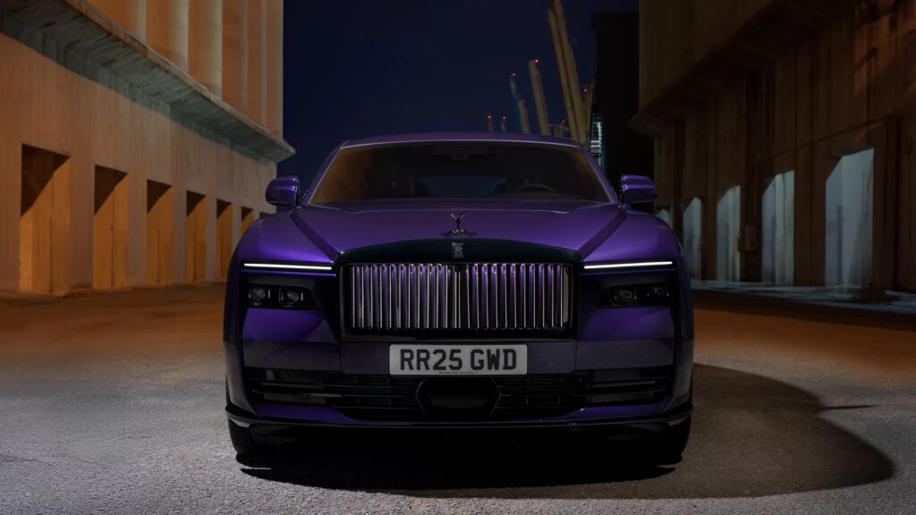 Front view of Rolls-Royce Spectre in purple under urban night lights