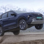 Tata Harrier EV airborne during an off-road test with snow-capped mountains in the background